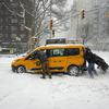 mimoidoči pomagajo rešiti avtomobil, ujet v snegu na ulicah New Yorka