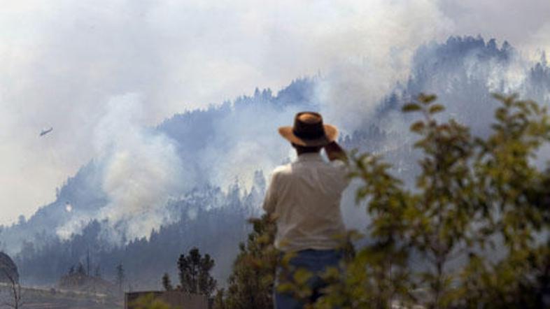 Ljudje lahko le od daleč opazujejo, kako jim ogenj uničuje domove.