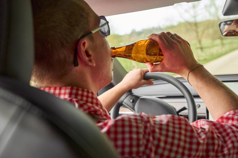 moški pije pivo za volanom