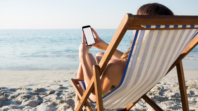 Ženska s telefonom na plaži