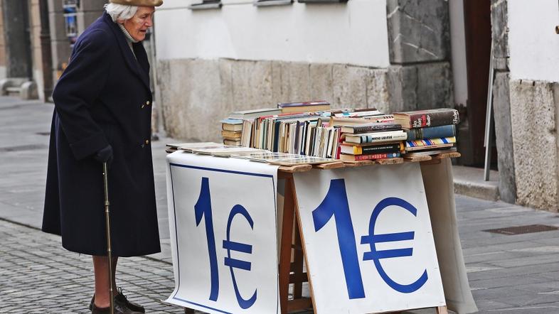 Slovenija 04.12.2013 starejsa zenska ogleduje stojnico s knjigami za 1 evro; fot